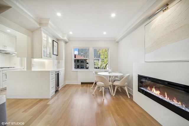 4300 N Marine Dr Unit 306, Chicago, IL 60613 - dining space featuring wine cooler, a glass covered fireplace, light wood finished floors, baseboards, and recessed lighting