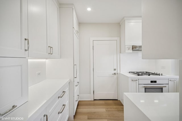 4300 N Marine Dr Unit 306, Chicago, IL 60613 - kitchen with stainless steel gas cooktop, oven, light wood finished floors, white cabinets, and light countertops