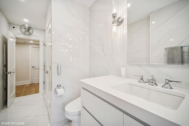 4300 N Marine Dr Unit 306, Chicago, IL 60613 - bathroom featuring tile walls, vanity, toilet, marble finish flooring, and recessed lighting
