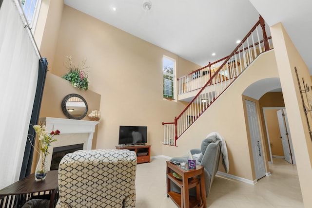 307 Lake Gillilan Way, Algonquin, IL 60102 - living room featuring a high ceiling, stairs, arched walkways, baseboards, and a fireplace