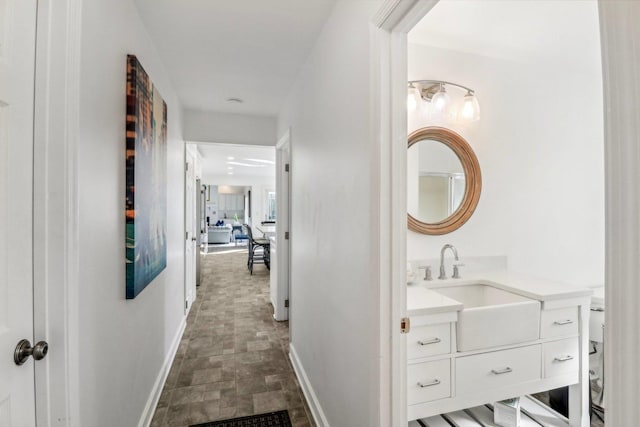 723 Beacon Dr, Lake Barrington, IL 60010 - hall featuring baseboards, stone finish flooring, and a sink