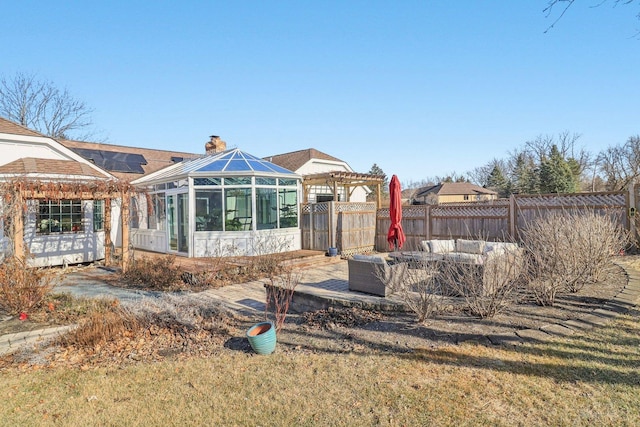 723 Beacon Dr, Lake Barrington, IL 60010 - rear view of house with solar panels, a chimney, a sunroom, an outdoor hangout area, and fence