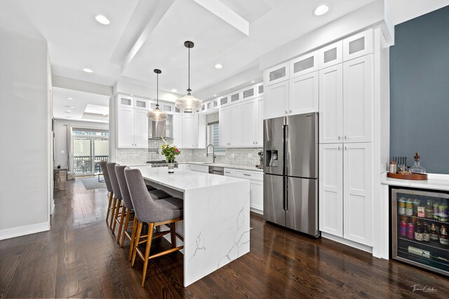 2629 W Homer St, Chicago, IL 60647 - kitchen featuring stainless steel appliances, beverage cooler, a sink, dark wood finished floors, and backsplash