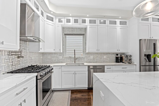 2629 W Homer St, Chicago, IL 60647 - kitchen featuring stainless steel appliances, a sink, wall chimney exhaust hood, and white cabinets