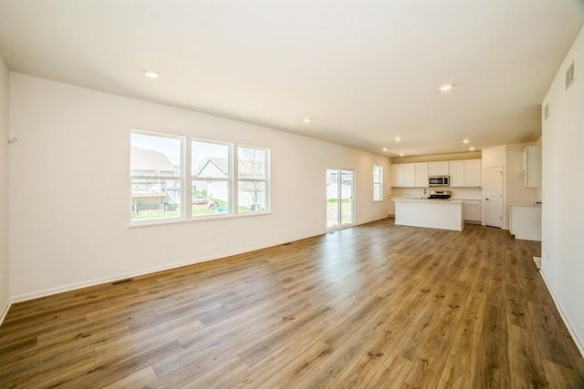 540 N Sycamore St, Hinckley, IL 60520 - unfurnished living room featuring light wood-type flooring, recessed lighting, and baseboards
