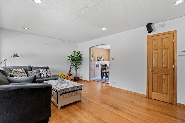 7217 W 57th St, Summit, IL 60501 - living room with arched walkways, light wood-style flooring, a textured ceiling, recessed lighting, and baseboards