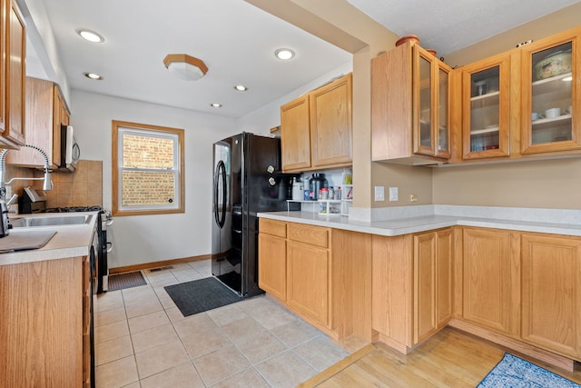 7217 W 57th St, Summit, IL 60501 - kitchen featuring stainless steel microwave, freestanding refrigerator, light countertops, glass insert cabinets, and tasteful backsplash