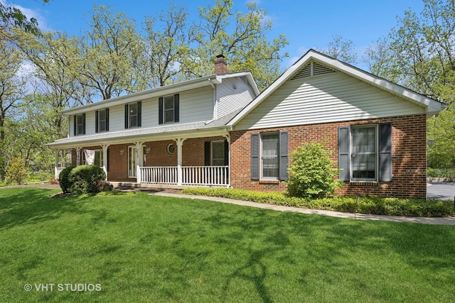 5808 Amherst Ct, Mchenry, IL 60050 - view of front of house with brick siding, a chimney, a front lawn, and covered porch
