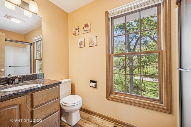 5808 Amherst Ct, Mchenry, IL 60050 - bathroom with vanity, toilet, wood finished floors, a shower with door, and baseboards