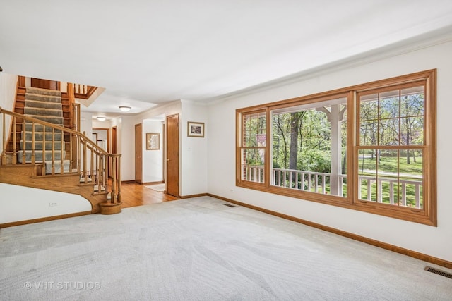 5808 Amherst Ct, Mchenry, IL 60050 - unfurnished living room featuring carpet, baseboards, stairway, and crown molding