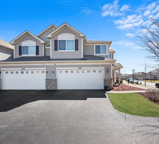 217 Owen St, Matteson, IL 60443 - view of property featuring stone siding, driveway, and a garage