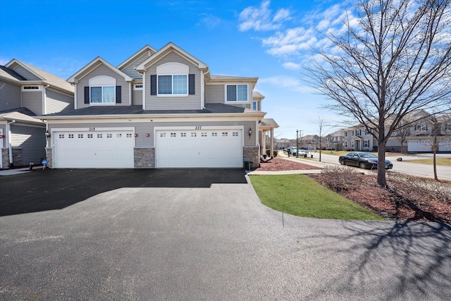 217 Owen St, Matteson, IL 60443 - view of property featuring asphalt driveway, a garage, and stone siding