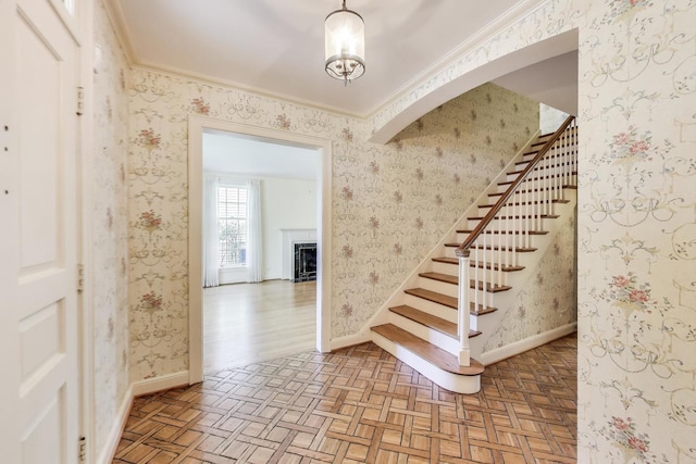 915 Pontiac Rd, Wilmette, IL 60091 - stairway featuring crown molding, a fireplace, parquet floors, and baseboards