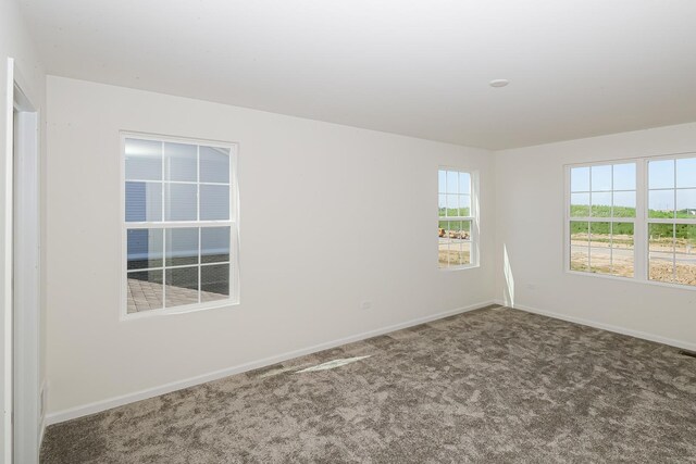 carpeted empty room featuring baseboards
