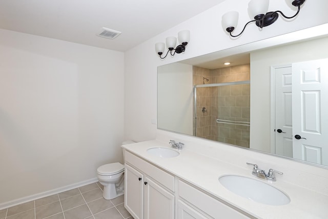 full bath featuring tiled shower, toilet, tile patterned flooring, double vanity, and baseboards