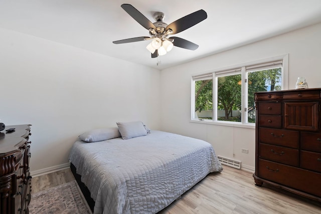bedroom with baseboards, light wood finished floors, and ceiling fan