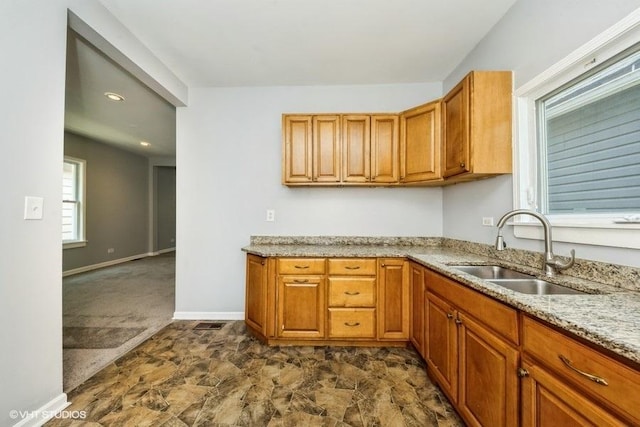 1505 E 76th Pl, Chicago, IL 60619 - kitchen with light stone countertops, brown cabinetry, and stone finish floors