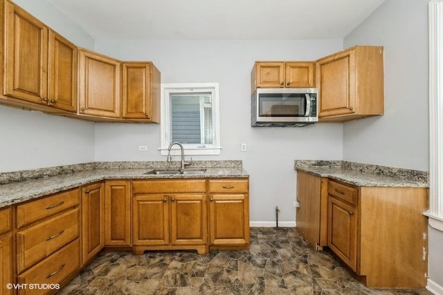 1505 E 76th Pl, Chicago, IL 60619 - kitchen featuring stainless steel microwave, light stone countertops, and brown cabinetry