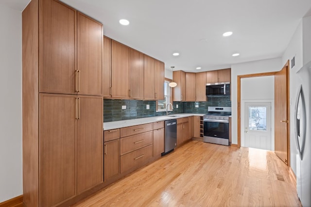 2934 Maple Ave, Berwyn, IL 60402 - kitchen with appliances with stainless steel finishes, light countertops, tasteful backsplash, light wood-type flooring, and healthy amount of natural light