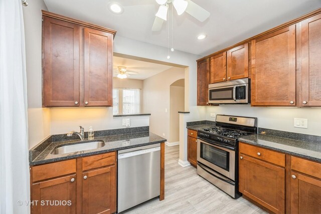 50 Forest Ave Unit 3S, Riverside, IL 60546 - kitchen featuring appliances with stainless steel finishes, a sink, ceiling fan, arched walkways, and dark stone counters