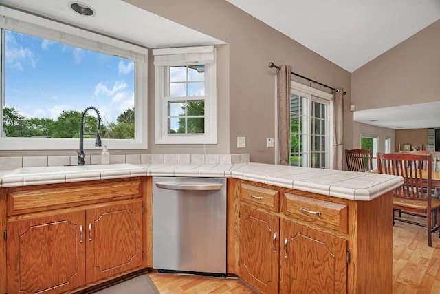 3513 Harris Dr, Joliet, IL 60431 - kitchen with stainless steel dishwasher, a sink, a peninsula, light wood finished floors, and vaulted ceiling
