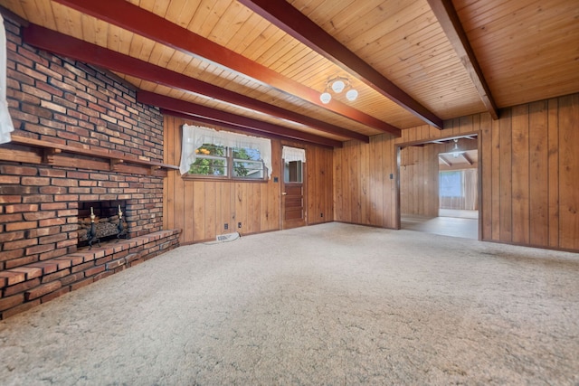 214 Hickory Ln, Momence, IL 60954 - unfurnished living room featuring carpet floors, wood walls, a wood ceiling with exposed beams, and a brick fireplace