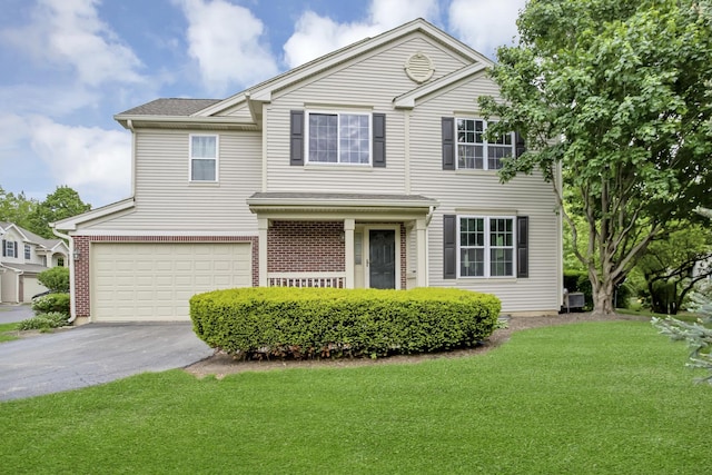 2451 Stonegate Rd Unit 2451, Algonquin, IL 60102 - traditional-style home featuring an attached garage, driveway, a front lawn, and brick siding