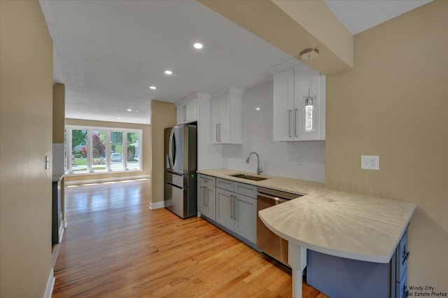 215 S Forest Ave, Palatine, IL 60074 - kitchen with stainless steel appliances, a sink, light wood-type flooring, light countertops, and decorative backsplash