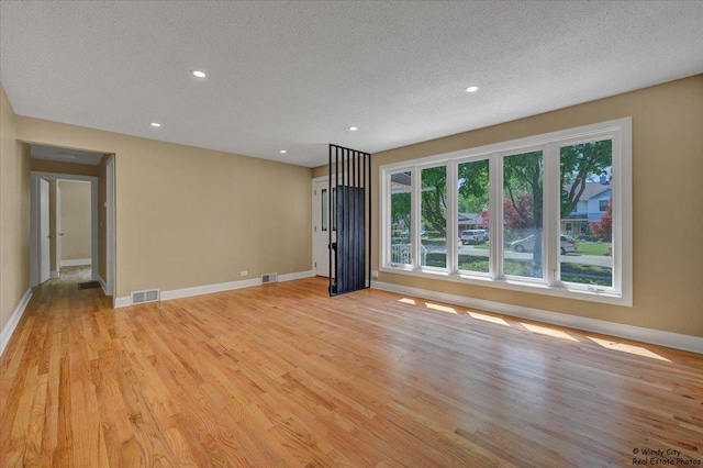 215 S Forest Ave, Palatine, IL 60074 - empty room with baseboards, plenty of natural light, a textured ceiling, light wood-style flooring, and recessed lighting