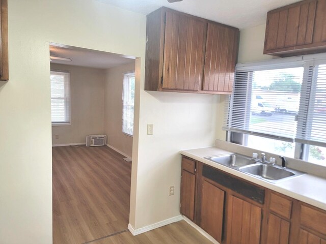 1211 S Clayton St, Bloomington, IL 61701 - kitchen featuring light wood-style floors, light countertops, a sink, baseboards, and brown cabinets