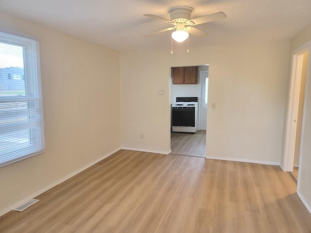 1211 S Clayton St, Bloomington, IL 61701 - spare room featuring light wood-type flooring, baseboards, and a ceiling fan