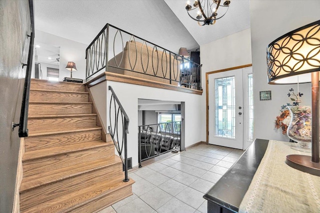 1016 W Willow Ln, Mount Prospect, IL 60056 - entrance foyer with tile patterned floors, stairway, a chandelier, high vaulted ceiling, and a textured ceiling
