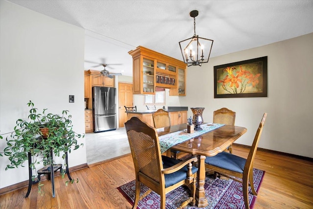 1016 W Willow Ln, Mount Prospect, IL 60056 - dining space featuring a chandelier, baseboards, light wood-type flooring, and a ceiling fan