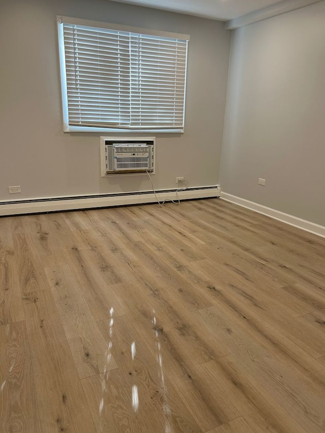 8521 Lotus Ave Unit 706, Skokie, IL 60077 - spare room with wood finished floors, a baseboard heating unit, a wall mounted air conditioner, and baseboards