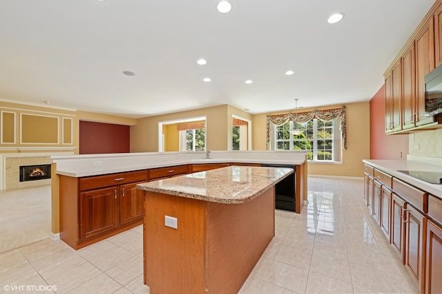 13881 Traverse Ct, Huntley, IL 60142 - kitchen with a spacious island, light tile patterned floors, brown cabinets, a glass covered fireplace, and recessed lighting