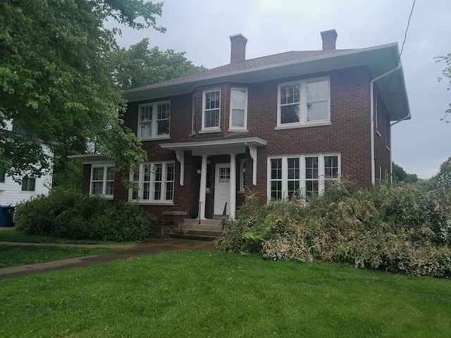516 S Grant St, Earlville, IL 60518 - view of front facade featuring a chimney, a front yard, and brick siding