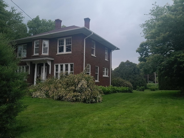 516 S Grant St, Earlville, IL 60518 - view of property exterior featuring a chimney, a yard, and brick siding