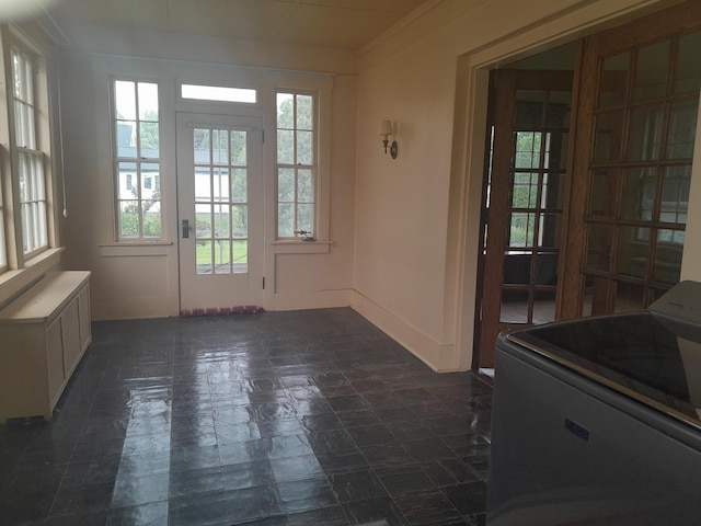 516 S Grant St, Earlville, IL 60518 - doorway with radiator heating unit, plenty of natural light, washer / dryer, dark stone finish floors, and ornamental molding