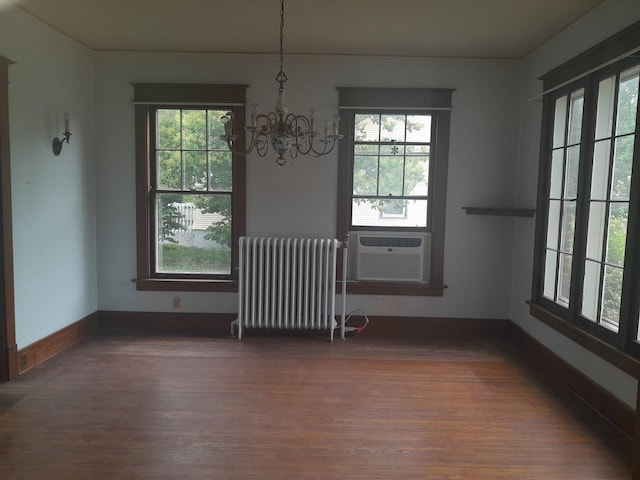 516 S Grant St, Earlville, IL 60518 - unfurnished dining area with radiator heating unit, a chandelier, wood finished floors, and healthy amount of natural light