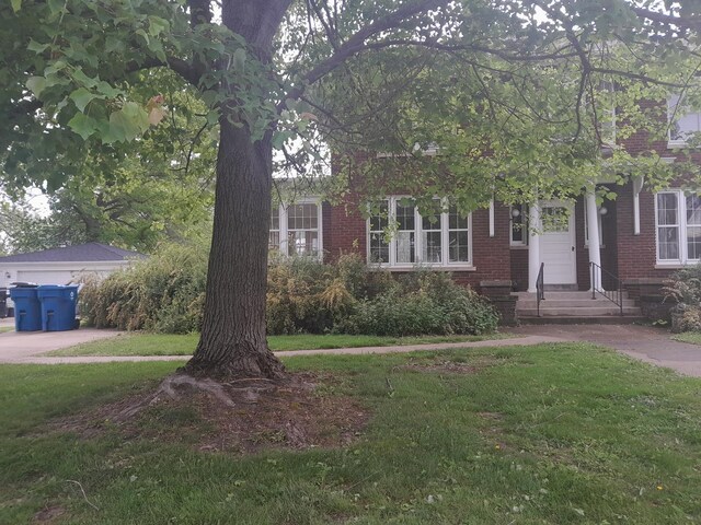 516 S Grant St, Earlville, IL 60518 - obstructed view of property featuring a front yard, entry steps, and brick siding