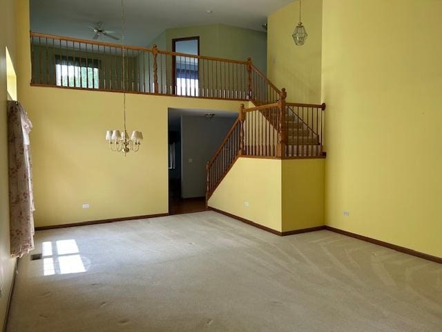 13804 Ironwood Dr, Plainfield, IL 60544 - unfurnished living room featuring carpet, a chandelier, a ceiling fan, baseboards, and a high ceiling