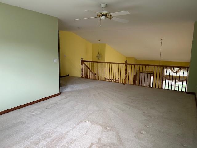 13804 Ironwood Dr, Plainfield, IL 60544 - carpeted spare room with vaulted ceiling, ceiling fan, and baseboards