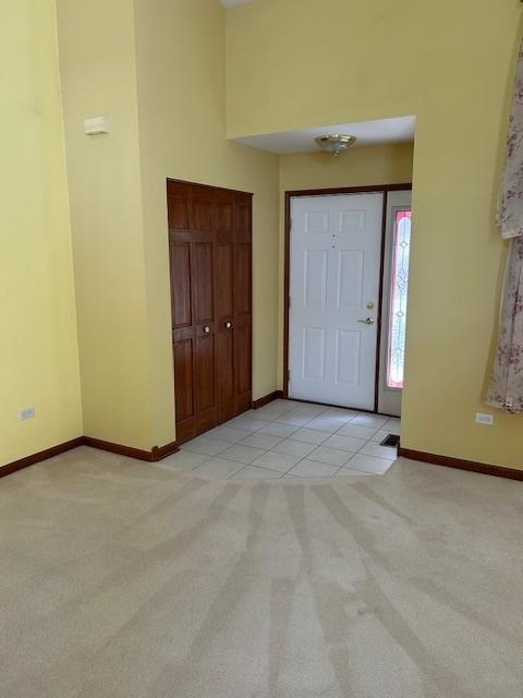 13804 Ironwood Dr, Plainfield, IL 60544 - entryway featuring light colored carpet, baseboards, light tile patterned floors, and a high ceiling