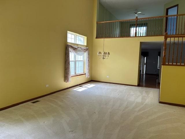 13804 Ironwood Dr, Plainfield, IL 60544 - spare room featuring carpet floors, a high ceiling, baseboards, a chandelier, and a ceiling fan