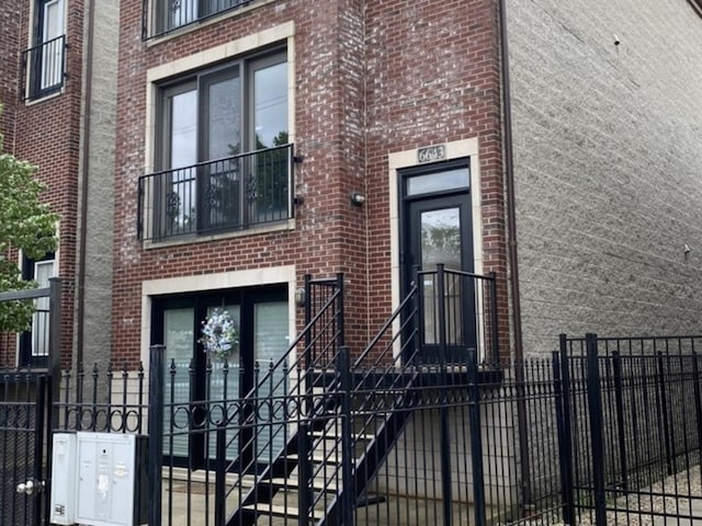 6643 W Belmont Ave Unit 1, Chicago, IL 60634 - doorway to property featuring brick siding and fence