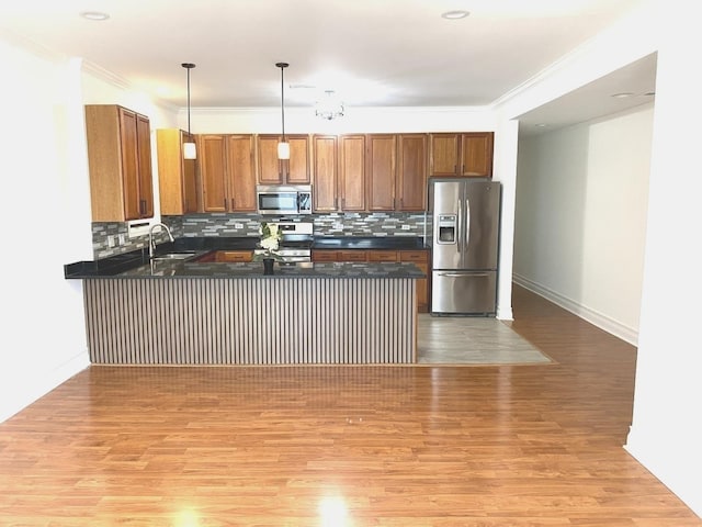 6643 W Belmont Ave Unit 1, Chicago, IL 60634 - kitchen featuring appliances with stainless steel finishes, dark countertops, a peninsula, a sink, and tasteful backsplash