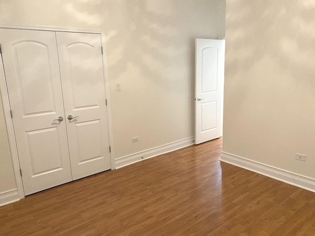 6643 W Belmont Ave Unit 1, Chicago, IL 60634 - unfurnished bedroom featuring dark wood-style floors, baseboards, and a closet