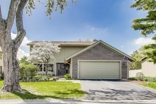 609 Bryce Trl, Roselle, IL 60172 - view of front of home with brick siding, a garage, a chimney, and asphalt driveway