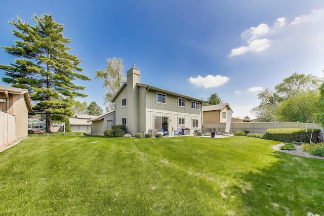 609 Bryce Trl, Roselle, IL 60172 - back of property with a chimney, board and batten siding, and a patio area