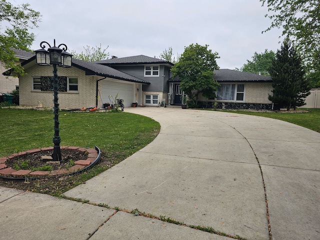 split level home with a garage, a front lawn, concrete driveway, and brick siding